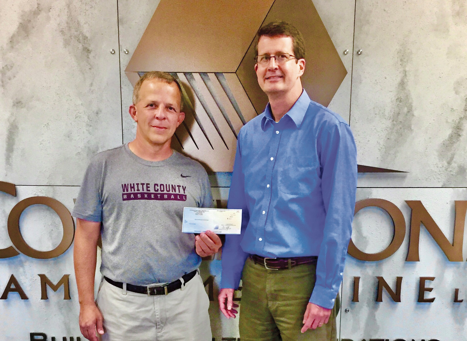 Brent Ryan (left), White County schools’ certified athletic trainer, accepts a check from Dr. Chad Griffin for the purchase of Schutt brand splash face shields for White County High School and White County Middle School football players.